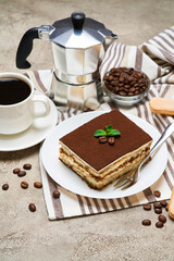 Portion of Traditional Italian Tiramisu dessert and savoiardi cookies on grey concrete background