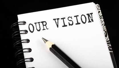 OUR VISION written text in a small notebook on a black background