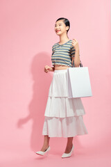 Portrait beautiful young asian woman with white shopping bag on pink isolated background