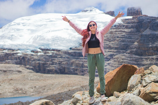 Vertical shot of a happy Colombian woman near a glacial lake in El Cocuy National Park , Colombia