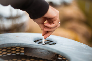 Man puts out a cigarette. Focus is on hand.