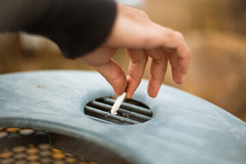 Man puts out a cigarette. Focus is on hand.