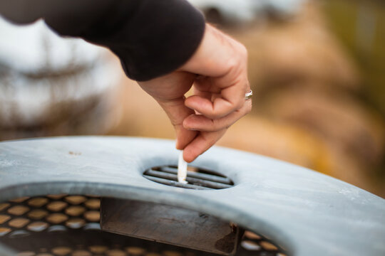 Man puts out a cigarette. Focus is on hand.