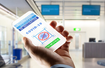 safe travel, technology and health care concept - close up of hand holding smartphone with international certificate of vaccination or virtual immunity passport on screen over airport background