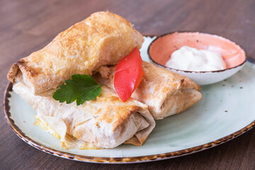 Three spring rolls with sour cream. Pancakes Semi-finished product.