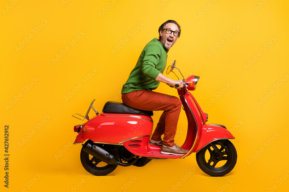 Poster photo of crazy man ride moped travel enjoy wear glasses green pullover pants footwear isolated yello