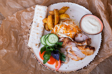 Vegetable salad with chicken. Sliced vegetables with meat on a plate. Shawarma on a plate with pita bread top view.