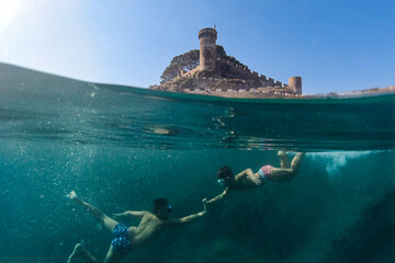 Two little boys snorkeling with a castle in the background