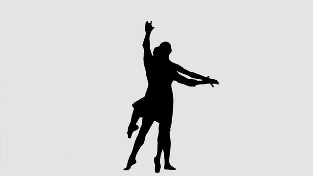 Silhouette professional ballet pair practicing moves on dark stage. Gracefulness and tenderness in every movement.