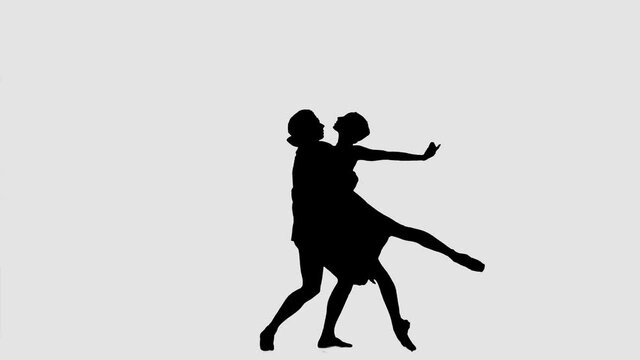 Silhouette professional ballet pair practicing moves on dark stage. Gracefulness and tenderness in every movement.
