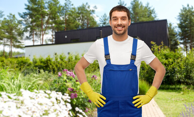 profession, cleaning service and building concept - happy smiling male worker or cleaner in overall...