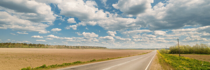 Fototapeta premium Endless country road to the horizon extra wide panoramic
