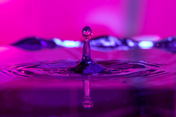 Reflejo de una gota de agua con fondo azul y rosa