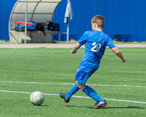 Obraz premium Children's football. An interesting football moment at the match and training. The active struggle and dynamics of the boys' soccer match. The boys are recklessly fighting for the ball