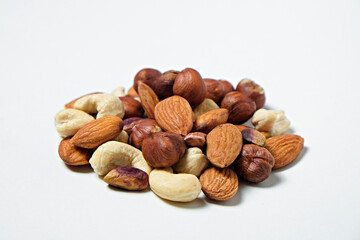 Pile of mixed nuts and dried berries isolated on white background. Healthy high-calorie vegan food concept. Close up, copy space, top view, flat lay.