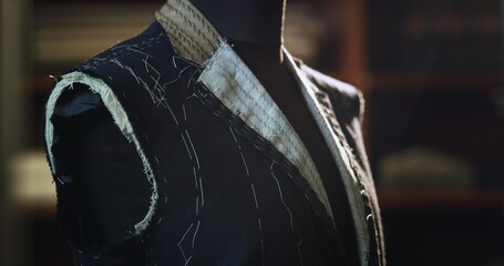 Close up of custom made high quality tailored suit by designer on tailor mannequin in luxury...