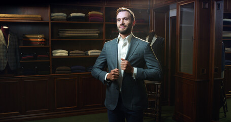 Cinematic close up shot of young businessman is smiling satisfied with his new custom made high quality tailored suit by designer in luxury tailoring atelier.Concept of fashion, handmade, hand craft, 