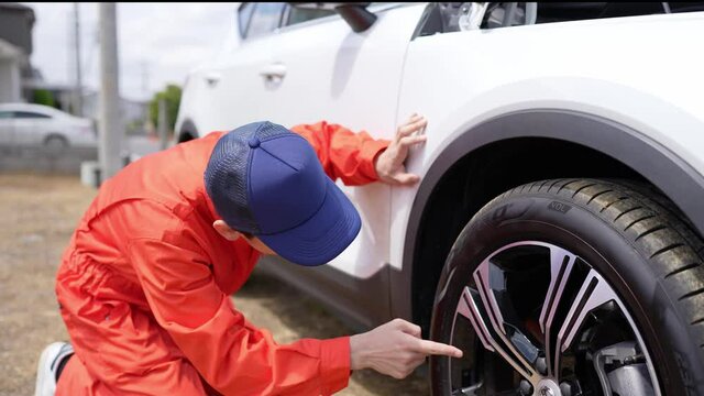 自動車のタイヤを点検する男性整備員