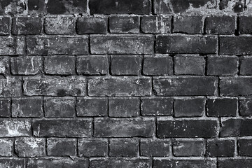 Fototapeta premium Dark brick wall with soot and grime. Real old building facade background for decor and design posters and banners