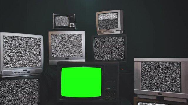 Zoom out then fixed shot in a old tv set with green screen among a wall of retro television