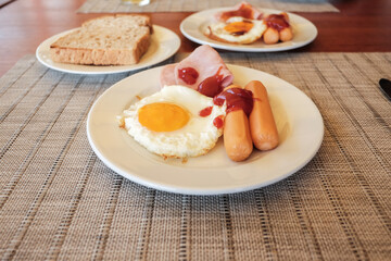 delicious breakfast with fried egg pork sausage and ham bread toasted for two at the hotel