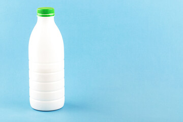 kefir in a plastic bottle with a green tube on a blue background,space for text