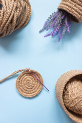 The knitted part of the basket made of jute rope and a crochet hook. Hobbies, needlework, organization of space.