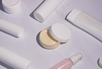 Cream in a jar with an open lid and bottles for cosmetics. shadows