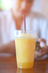 Orange juice shakes on a wooden table in a coffee shop.