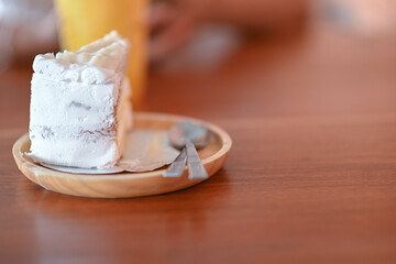 Coconut cake is placed on the wooden table in the cafe.