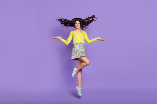 Full size photo of optimistic nice brunette curly lady jump wear sweater skirt sneakers isolated on purple color background