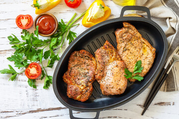 Barbecues parties menu. Baked meat pork loin on the bone with spices in a cast iron pan on rustic...