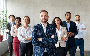 Businessman Standing In Front Of His Business Team In Office