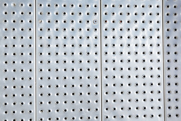 metal plate with texture. Metal floor with holes for water leakage. Aluminum sheet with many round holes. Iron parapet in the port 