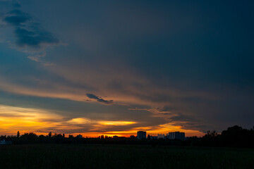 Natural Sunset Sunrise Over Field Or Meadow. Bright Dramatic Sky And Dark Ground. Countryside Landscape Under Scenic Colorful Sky At Sunset Dawn Sunrise. Sun Over Skyline, Horizon. Warm Colours