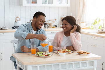 Obraz na płótnie Canvas Loving African American Family Of Two Having Breakfast In Kitchen