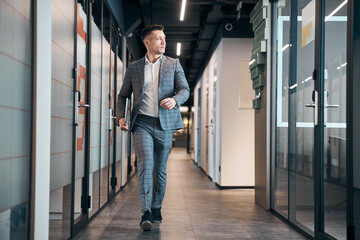 Stylish young man walking down the hallway