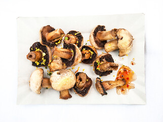 Champignon fried on paper plate. Cooked on fire veggies top view