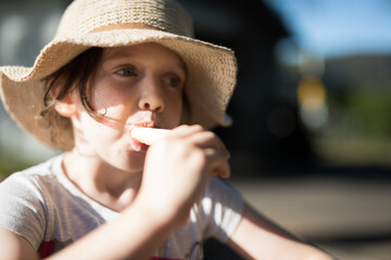 young caucasian girl child eating ice cream hat sun summer neutral fun food sweet