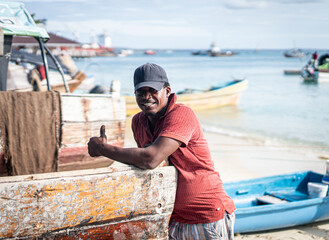 Candid black fisherman on coast ocean