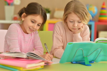 Two beautiful little girls doping homework