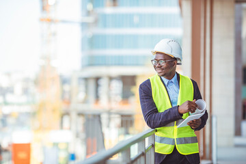 Fototapeta na wymiar Construction Worker Planning Contractor Developer Concept. Portrait of African American Engineer at a construction work site. Successful male architect at a building site