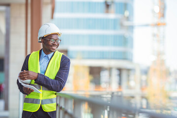 Construction Worker Planning Constractor Developer Concept. Portrait of an engineer holding a blueprint at a construction site. Overseeing the building process