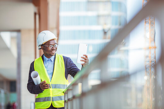 Construction Worker Planning Constractor Developer Concept. Portrait of an engineer holding a blueprint at a construction site. Overseeing the building process