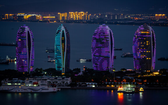 Phoenix island Ocean Dream Resort buildings illuminated in blue and purple at night scenic view in Sanya bay Hainan island China