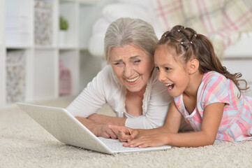  little girl with her grandmother  using  laptop