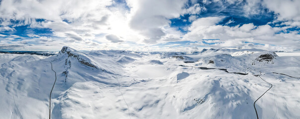 Spectacular panoramic view over snowcapped mountain peaks, ridges and frozen highland tundra in Jotunheimen, Norway. - obrazy, fototapety, plakaty