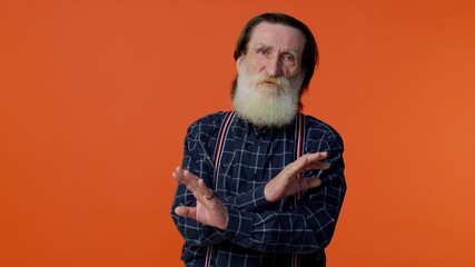 Elderly bearded gray-haired man say no hold hands crossed in stop gesture, warning of finish, prohibited access, declining communication, body language, danger. Senior old grandfather