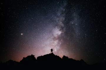 Fototapeten silueta una persona de pie mirando el campo de estrellas y la vía lactea © Jairo Díaz