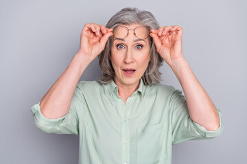 Portrait of attractive amazed gray-haired woman news reaction wow isolated over grey pastel color background